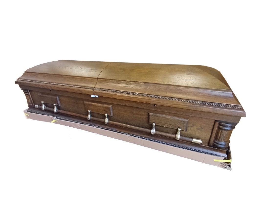 Montgomery oak veneer casket – Closed split-lid American-style casket with swing-bar handles and matte dark oak finish.